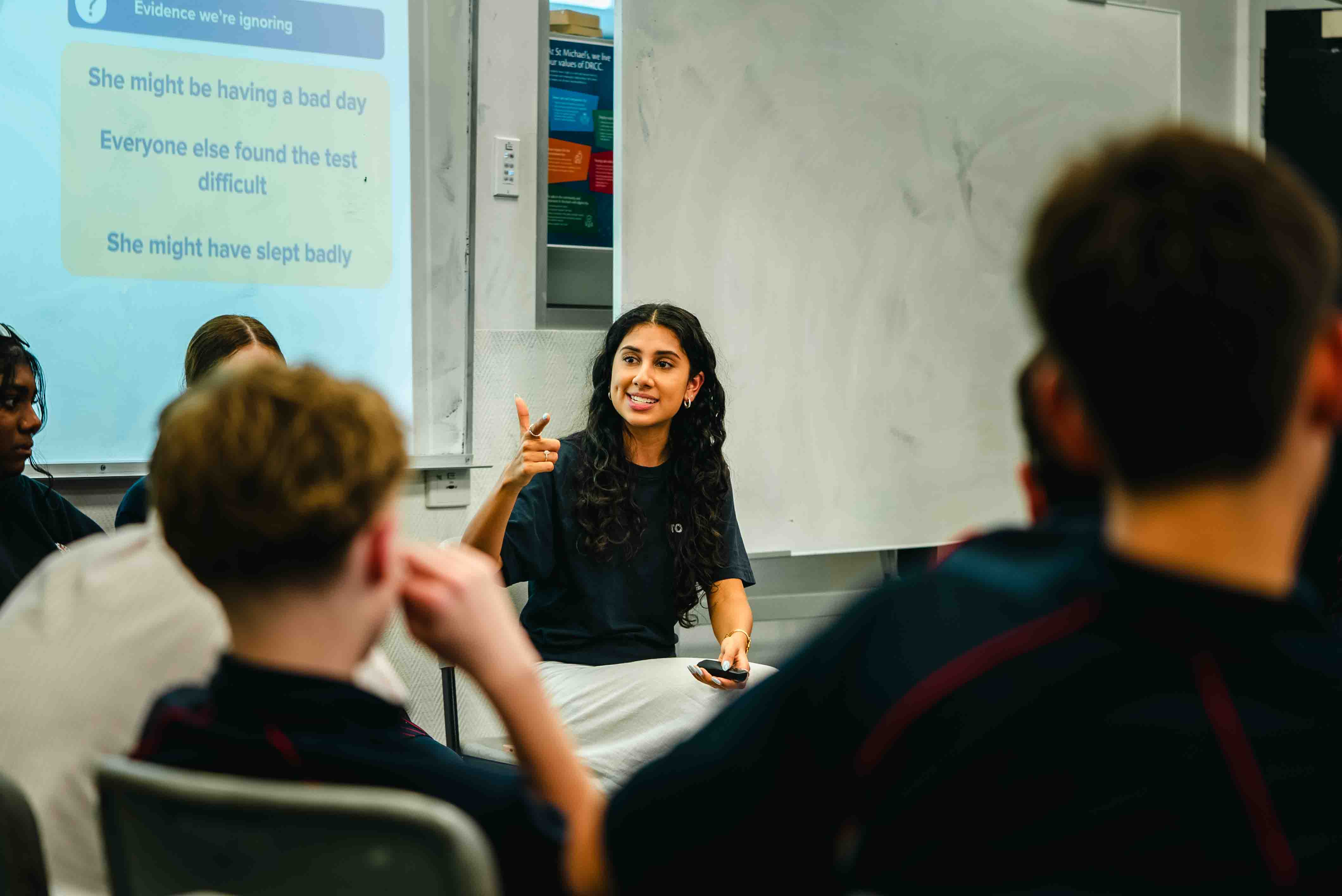 A Toolbox facilitator running a workshop activity with a whiteboard slide behind her
